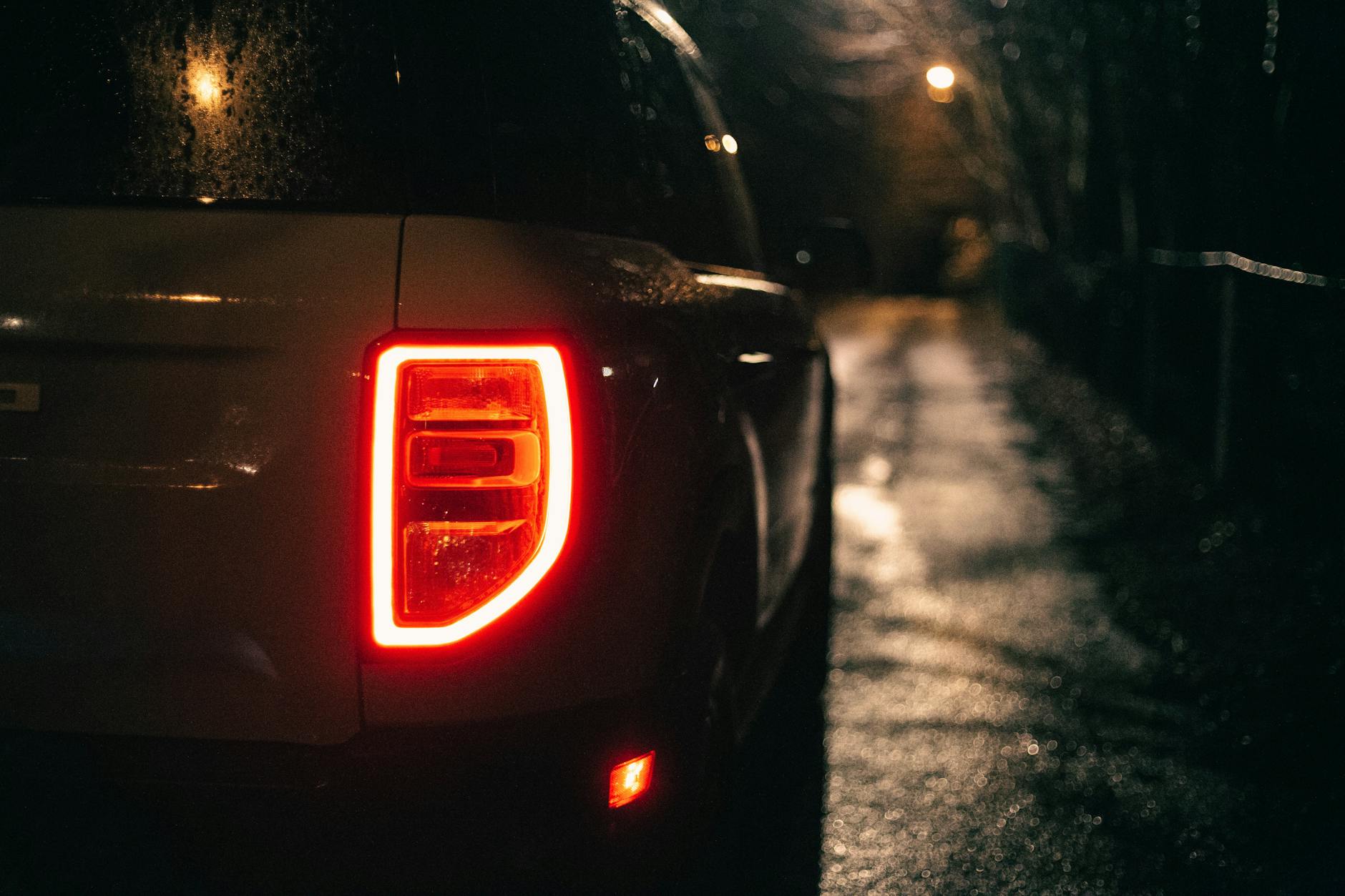 a close up shot of the tail light of a ford bronco sport at night